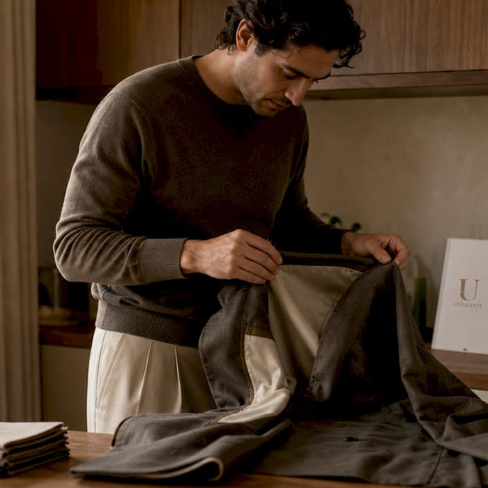 Person inspecting authentic designer jacket indoors