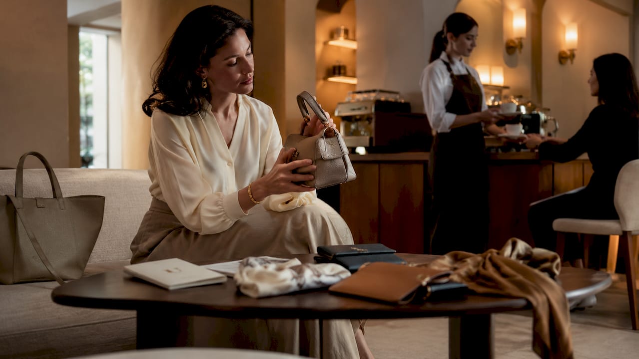 Woman examining designer handbag in boutique