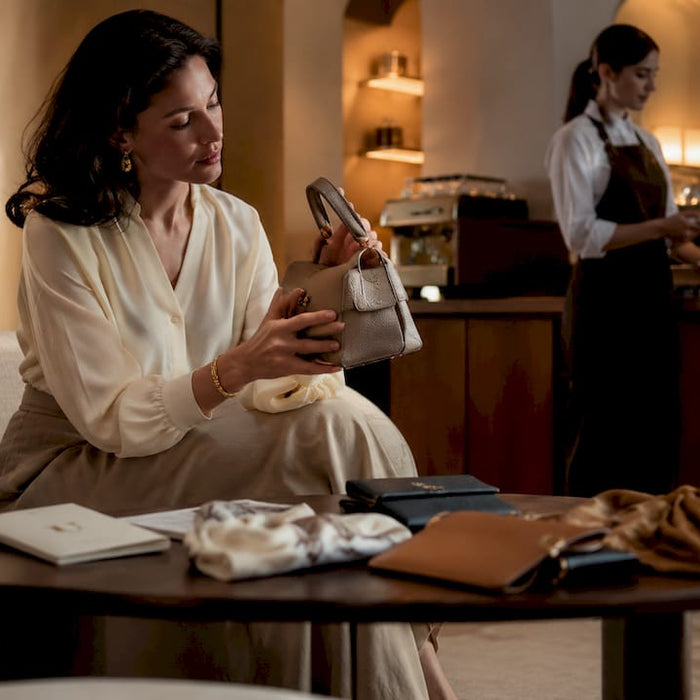 Woman examining designer handbag in boutique
