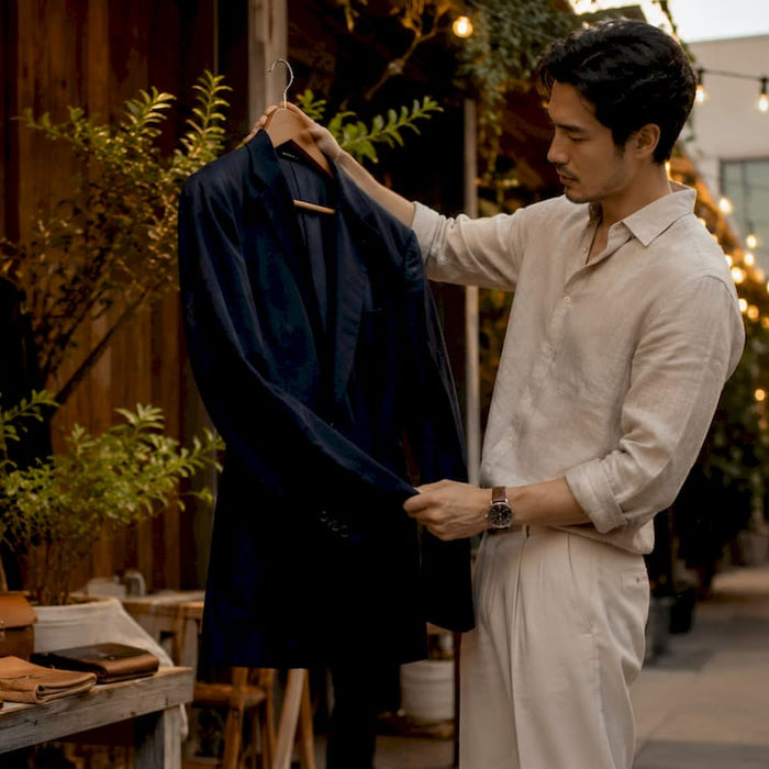 Man examining a designer blazer in boutique