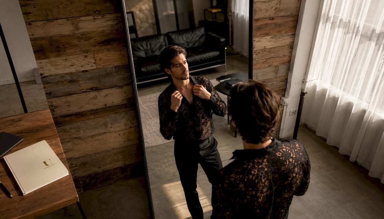 Man trying on designer shirt in modern apartment