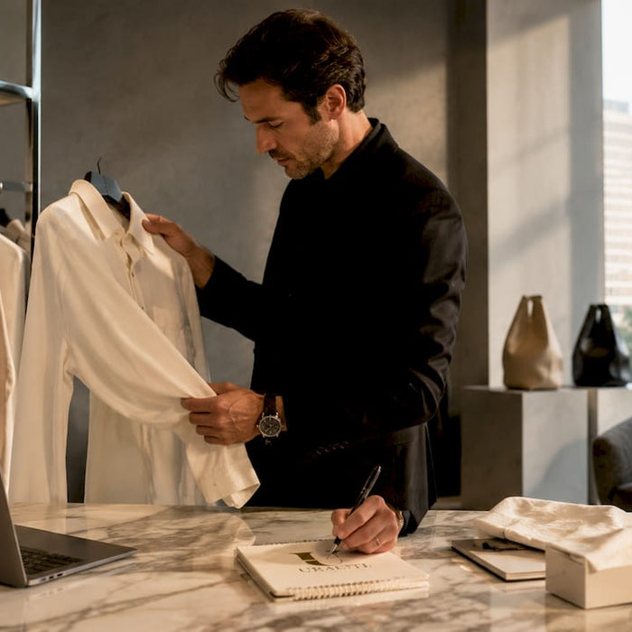 Stylist holding luxury designer shirt in boutique