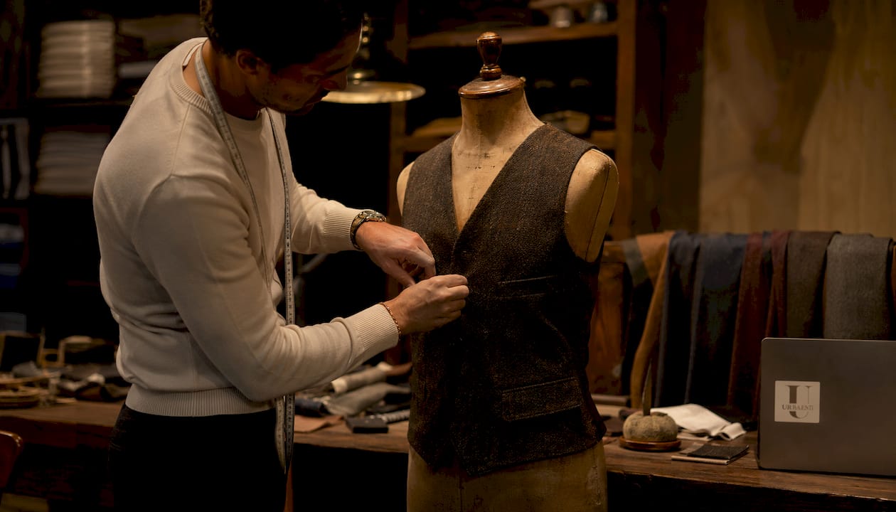 Designer vest on mannequin with stylist's hands