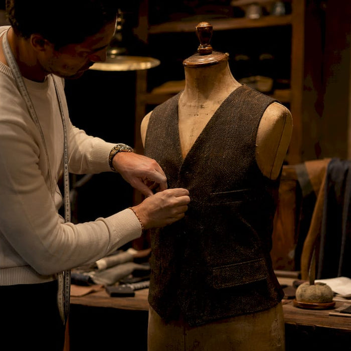 Designer vest on mannequin with stylist's hands