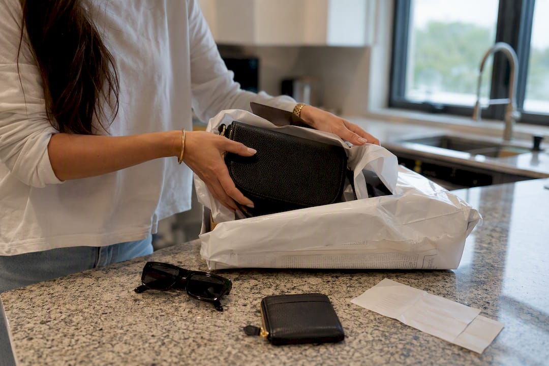 Hands unboxing parcel with designer bag