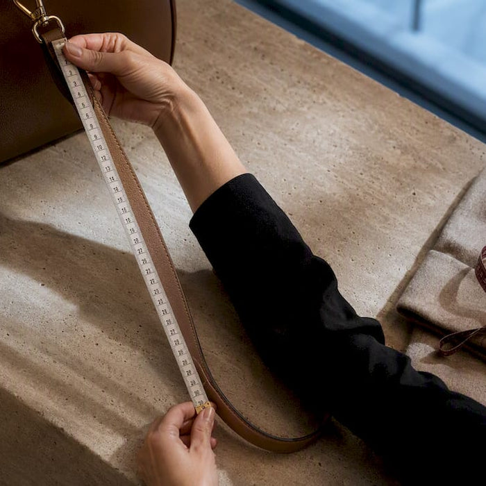 Measuring a handbag strap with centimeter tape
