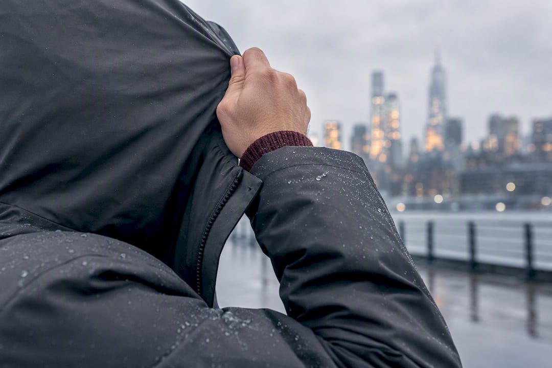 Man adjusting hood in winter wind