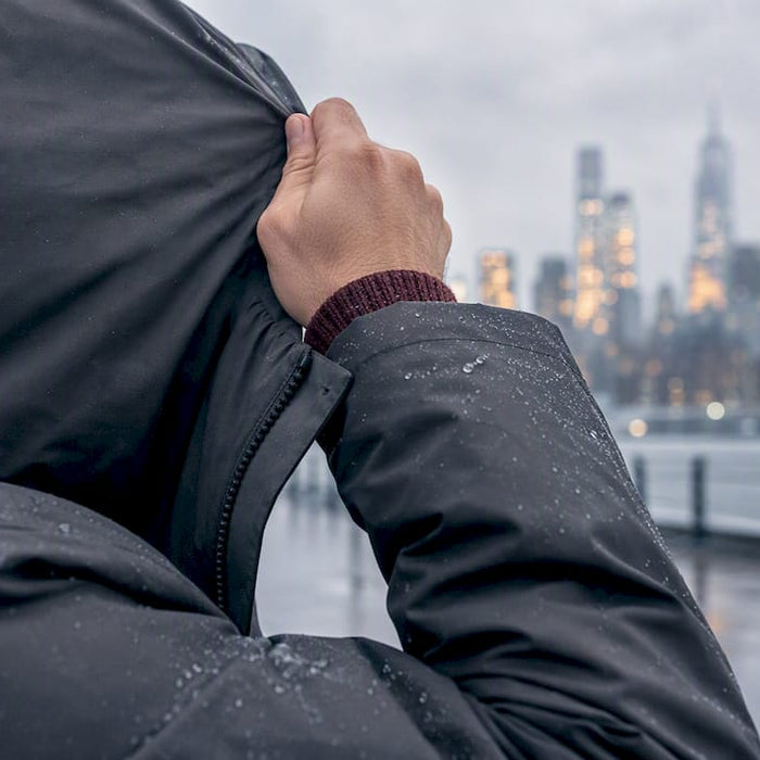 Man adjusting hood in winter wind