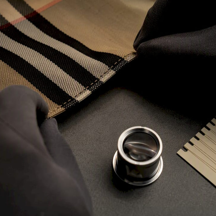 Hands inspecting luxury textile stitching
