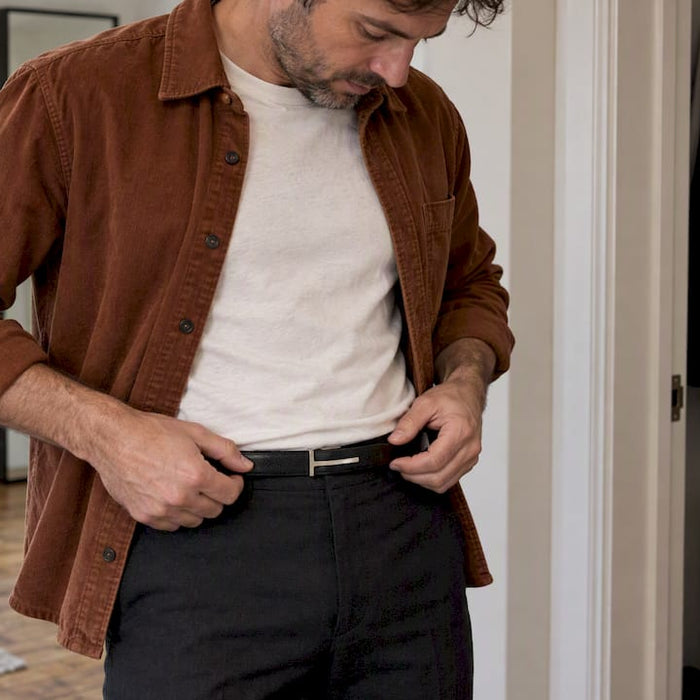Man fastening a slim designer leather belt