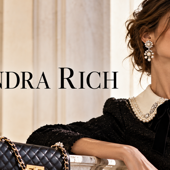 Alessandra Rich Designer Fashion from Italy featuring a woman in a black embellished dress with a pearl collar, crystal brooches, and quilted handbag in an elegant Italian setting