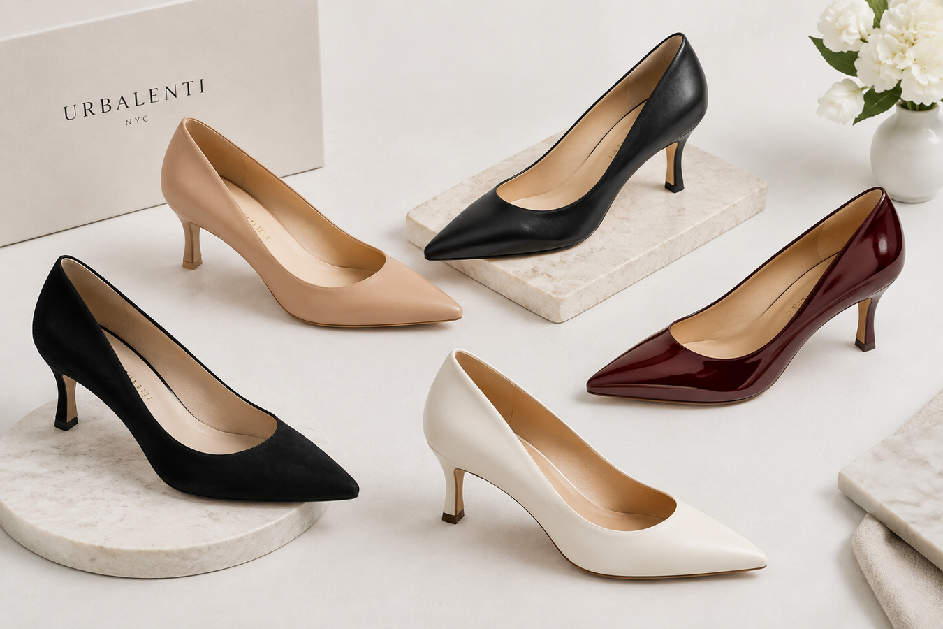 Designer Mid Heel Pumps for Women collection featuring black, beige, white, and burgundy pointed-toe pumps displayed on elegant stone platforms. Designer  Mid Heel Pumps for Women | Shop today at Urbalenti NYC