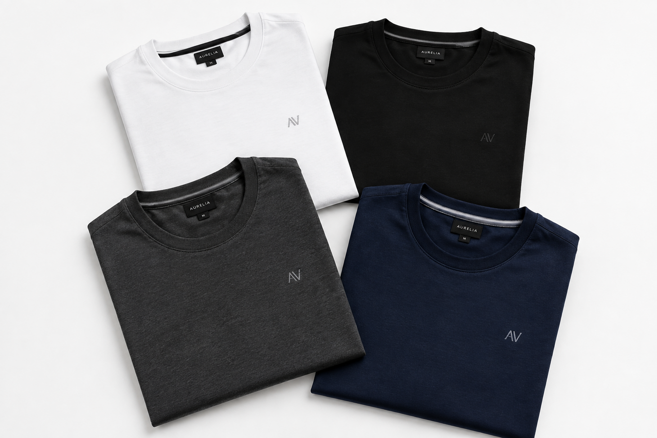 Four folded designer crewneck T-shirts in white, black, charcoal gray, and navy blue showcase the Designer Sportswear T-Shirts for Men collection. Shop Designer Sportswear T-Shirts for Men at Urbalenti NYC.