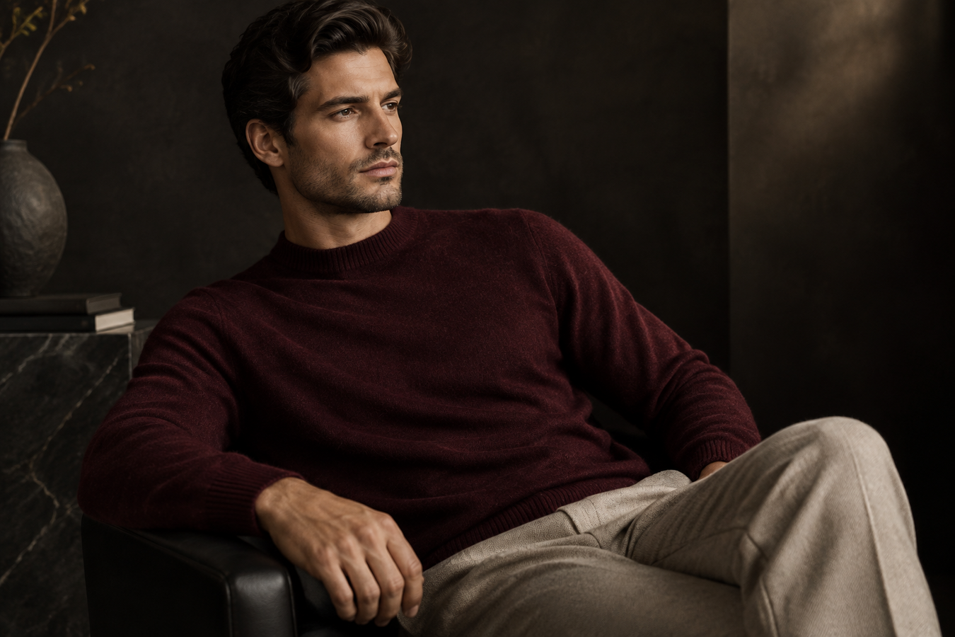 Man wearing a burgundy knit sweater and beige trousers, showcasing Men's Designer Sweaters in a refined lifestyle setting. Shop Men's Designer Sweaters Now at Urbalenti NYC.