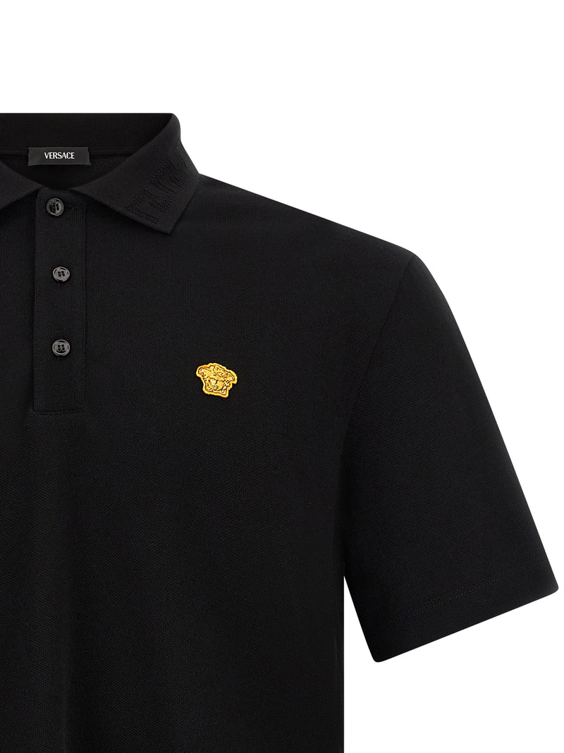 Close-up of the Versace Medusa Polo Shirt, highlighting the bold Medusa logo patch against the luxurious fabric, a staple piece by Versace for the Fall - Winter 2026/2027 collection. A chic choice for men's clothing and fashion. Men > Clothing > Shirts.