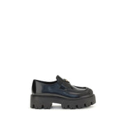 Prada Black Brushed Leather Slip-On Loafers for Women with Triangle Logo, side view showing polished calf leather, rounded toe, stitched apron, and chunky monobloc rubber sole. Prada Loafers for Women from Urbalenti NYC, style 13879, SKU 79661334579, Black, Discount_30-39, available in EU36.5/US6.5, EU36/US6, EU37/US7, EU38.5/US8.5, EU39/US9, and EU40/US10; in-stock, Loafers - Shoes, New with tags, Prada, Shoes, Slip-On Loafers - Loafers - Shoes, Women.
