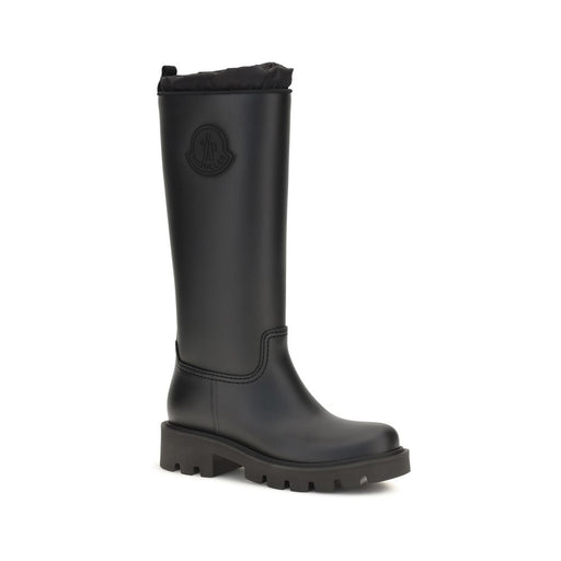 Moncler Black Waterproof Knee-High Rain Boots for Women, angled front view showcasing the sleek semi-matte finish, padded drawstring collar, round toe, and durable lug sole at Urbalenti NYC. Moncler Rain Boots for Women.