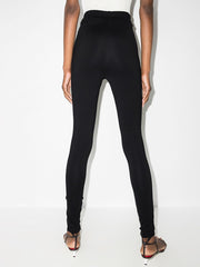 Rear view of 032C Black Front Zip Leggings with Zipped Pockets & Elastic Waistband, emphasizing its sleek design and elastic waistband. This authentic designer fashion piece is from 032C and showcases the modern luxury silhouette. Experience fashion shipped from Milano, including clothing, bags, shoes, jewelry, and accessories from renowned Italian designer boutiques. Discover curated luxury collections at competitive prices, fulfilled from Milan, Italy, and express delivered worldwide with confidence.