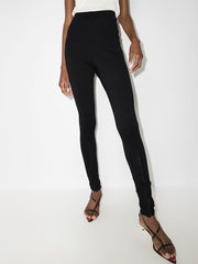 032C Black Front Zip Leggings with Zipped Pockets & Elastic Waistband, displayed with a focus on the high waistband and sleek fit, worn by a model.