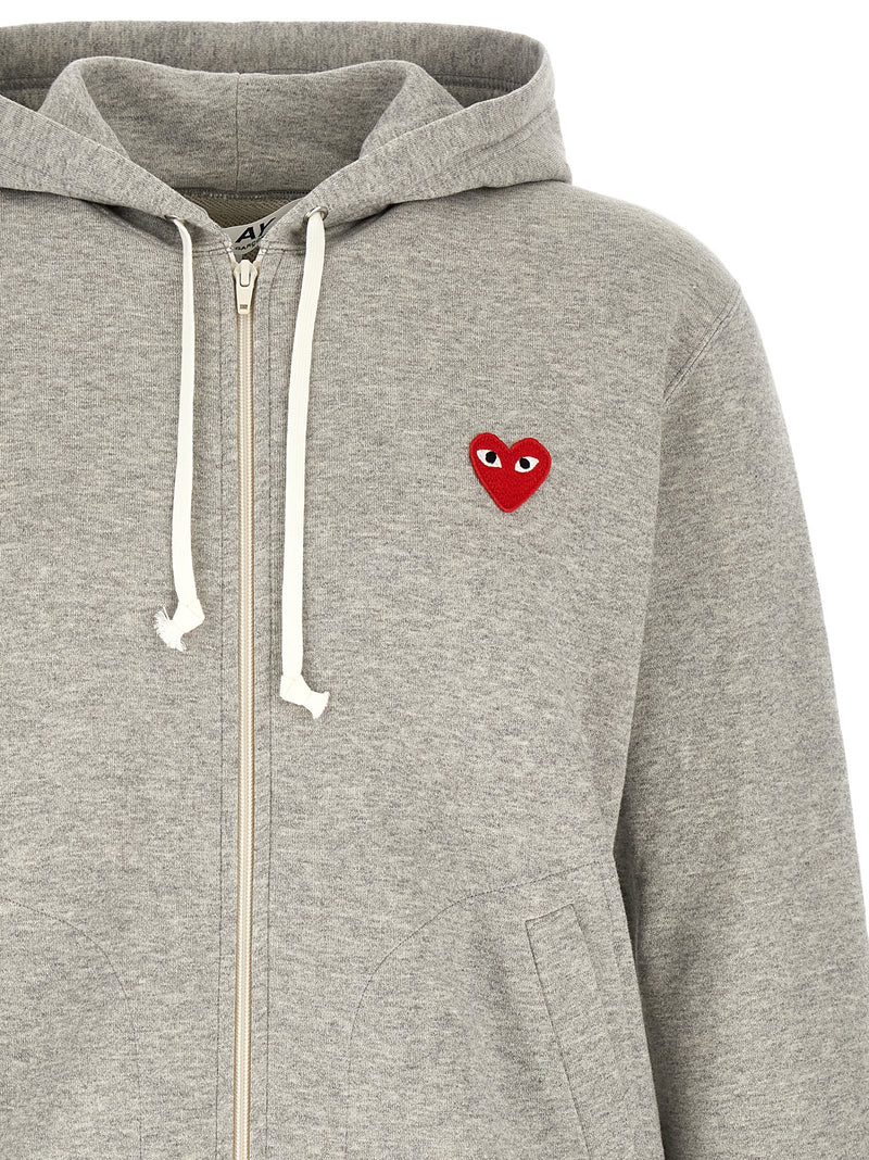 Close-up of the Comme Des Garçons Play Gray Cotton Hoodie for Men featuring the contrasting drawstrings, front zip, and iconic red PLAY heart patch. A detailed Comme Des Garçons Hoodie for Men in Gray, available in L, M, and XL, New with tags and in-stock under 13879, 79680700467, Cardigans - Sweaters - Clothing, Clothing, Comme Des Garçons Play, Discount_30-39, Men, Sweaters - Clothing.