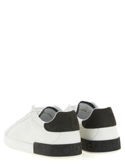 Dolce & Gabbana White Calfskin Low Top Sneakers for Men, rear view showing the dark gray heel inserts and embossed Dolce & Gabbana branding on the soles. These white Dolce & Gabbana Sneakers for Men are available at Urbalenti NYC, 13879, 79680700467, Discount_40-49, Dolce & Gabbana, EU 40 | US 7, EU 41 | US 8, EU 42 | US 9, EU43/US10, EU44/US11, EU45/US12, EU46/US13, EU47/US14, in-stock, Low Tops - Sneakers - Shoes, Men, New with tags, Shoes, Sneakers - Shoes, White.