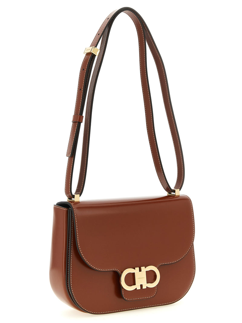 Ferragamo Double Gancini Leather Crossbody Bag for Women shown at an angle with its adjustable shoulder strap and gold-tone hardware, highlighting this refined brown Ferragamo Crossbody Bag for Women from Urbalenti NYC, 13879, 79680700467, Bags, Brown, Crossbody Bags - Bags, Discount_40-49, Ferragamo, in-stock, New with tags, Women.