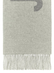 Jacquemus Wool Scarf, Jacquemus Gray Virgin Wool Scarf with Intarsia Logo and Fringes, close-up of soft gray virgin wool and long fringed edge at Urbalenti NYC