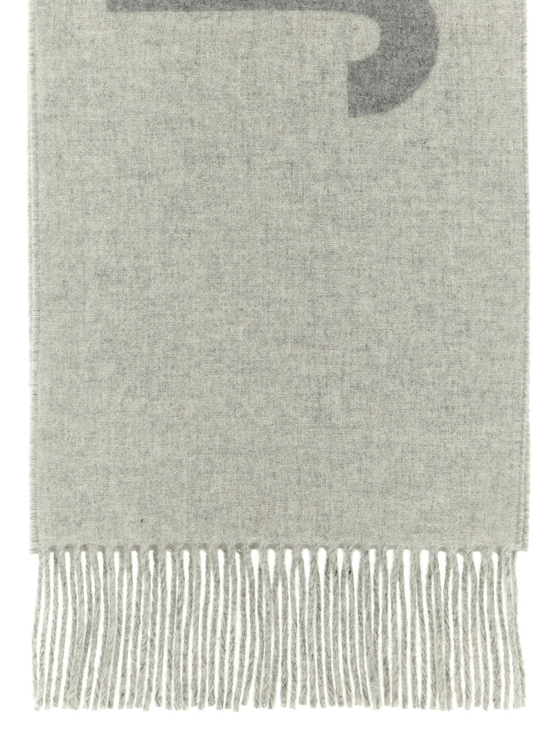 Jacquemus Wool Scarf, Jacquemus Gray Virgin Wool Scarf with Intarsia Logo and Fringes, close-up of soft gray virgin wool and long fringed edge at Urbalenti NYC