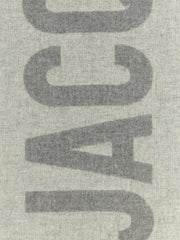 Jacquemus Wool Scarf, Jacquemus Gray Virgin Wool Scarf with Intarsia Logo and Fringes, detailed view of the bold gray intarsia logo on wool at Urbalenti NYC